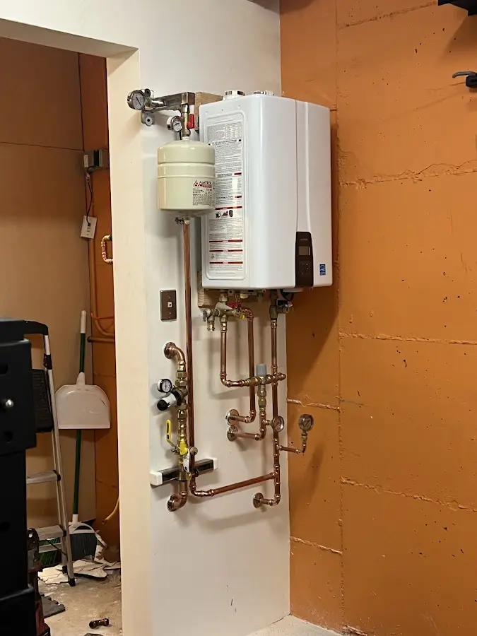 Plumbing technician inspecting water heater connections in Larose